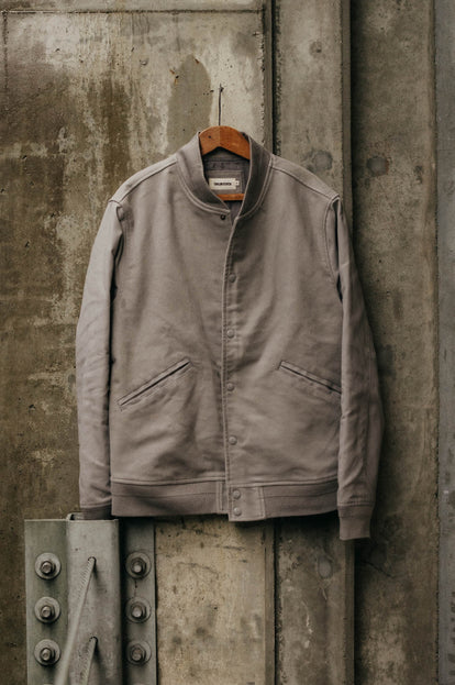 The Campus Jacket in Grey Moleskin hanging on a wall