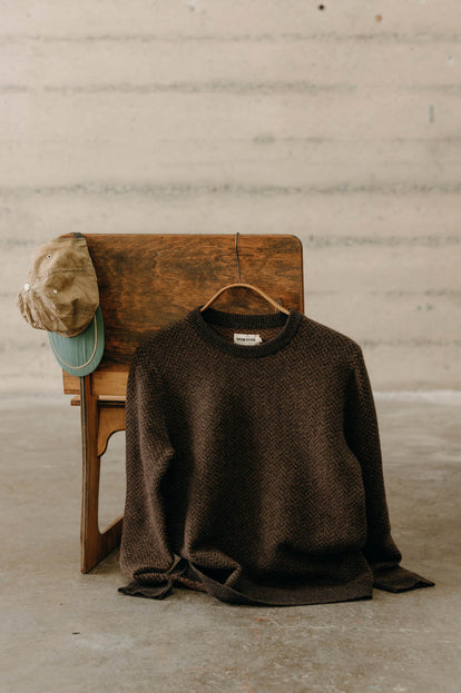 The Eddy Crew in Coffee Herringbone hanging on the back of a chair