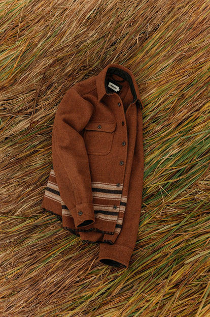 The Ranger Shirt in Tarnished Copper Blanket Stripe on top of grass