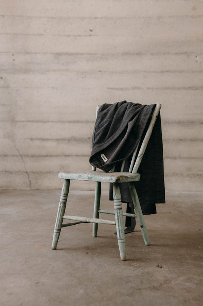 The Après Robe in Charcoal Sashiko draped over a chair