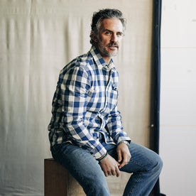 fit model sitting wearing The Utility Shirt in Sun Bleached Indigo Check, Wovens by Taylor Stitch